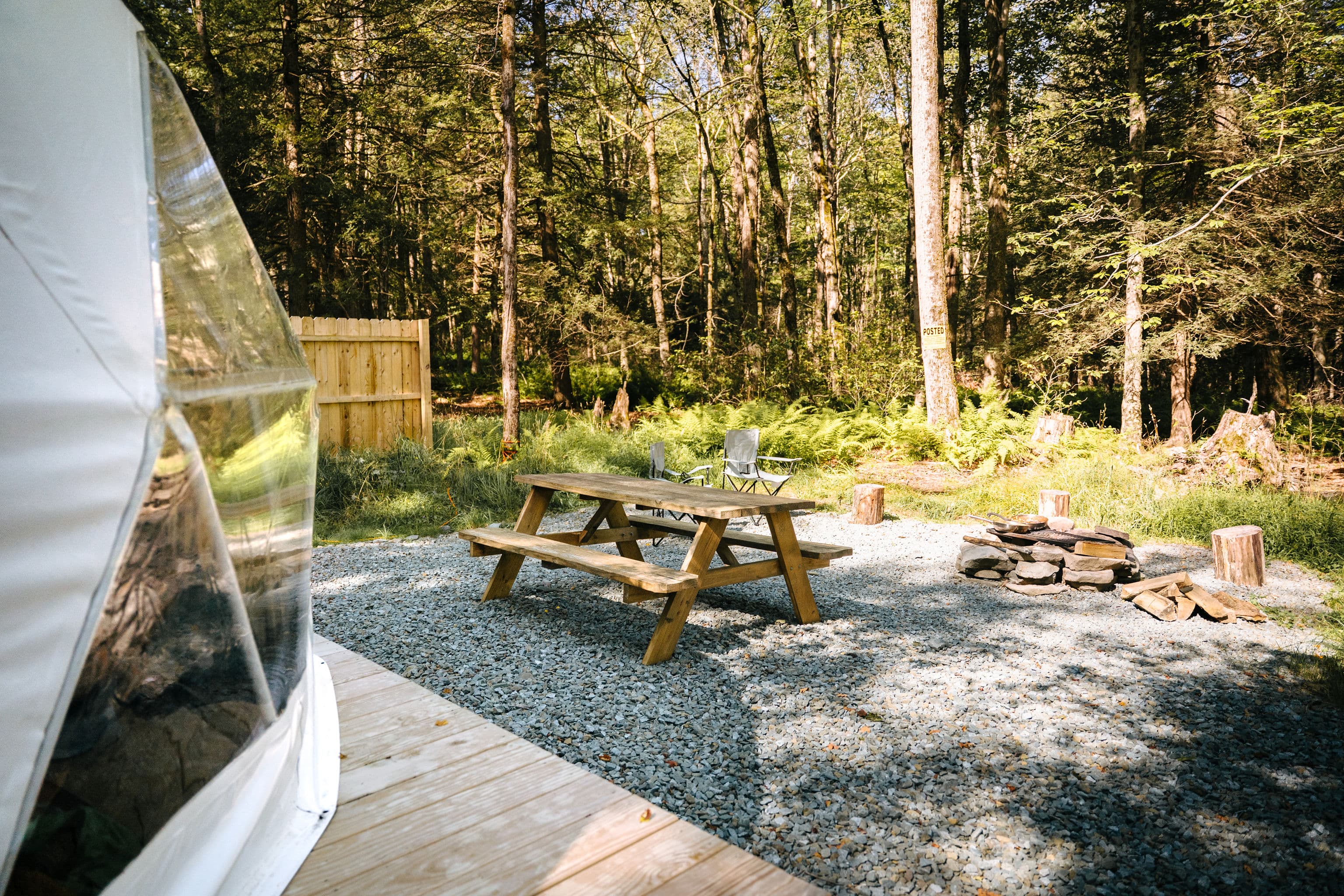 Outdoor picnic area and fire pit next to a Ferncrest dome